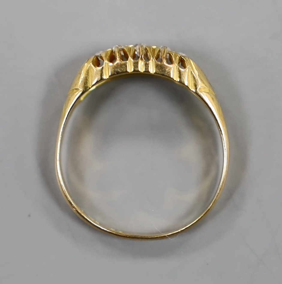 An early 20th century 18ct gold and graduated five stone diamond chip set half hoop ring, size Q, gross weight 3.2 grams.